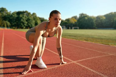 Spor giyim sektöründe koşuya hazır genç bir kadın. Sağlıklı yaşam tarzı, atletik eğitim ve rekabetçi zihniyet.