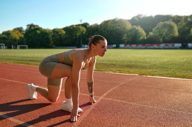Spor giyim sektöründe koşuya hazır genç bir kadın. Sağlıklı yaşam tarzı, atletik eğitim ve rekabetçi zihniyet.