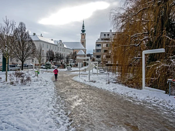 Stock image icy path from the embankment to the townhall and Friars Minor Conventual Church at winter in the city of Tulln on the river Danube, Austria