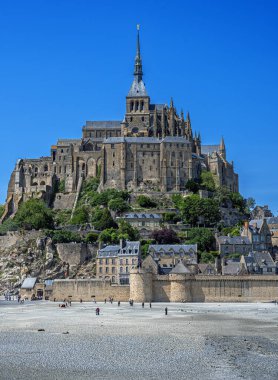 Mont-Saint-Michel adasında, Fransa 'nın Normandiya şehrinde, mavi gökyüzünden önce Manastır ve güneş altında.