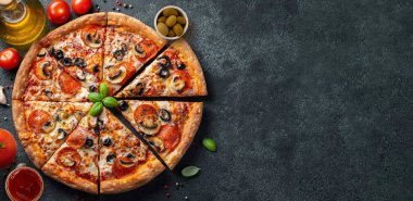 Lezzetli biberli pizza ve siyah beton arka planda domates fesleğeni. Acı biberli pizzanın en üst görüntüsü.. 