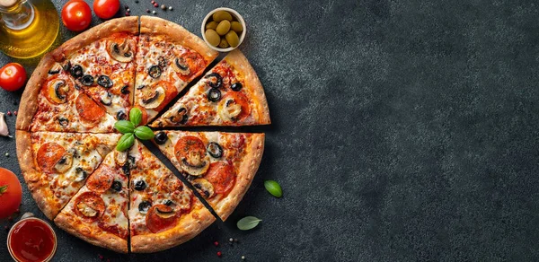 Lezzetli biberli pizza ve siyah beton arka planda domates fesleğeni. Acı biberli pizzanın en üst görüntüsü.. 