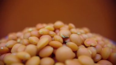 Red lentils rotate in a circle in slow motion