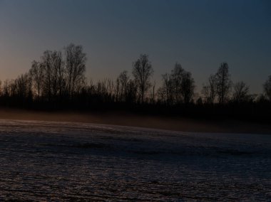 Soğuk kış gününde, kar ve buzla kaplı kırsal alan.