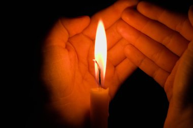 the candle is burning in his hands