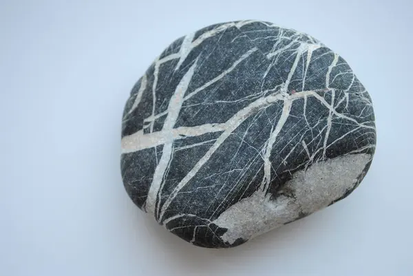 Beyaz doğal çizgileri ve açık arkaplanda desenleri olan pürüzsüz koyu bir taş. Yakından bakınca soyut doku ve organik tasarım.