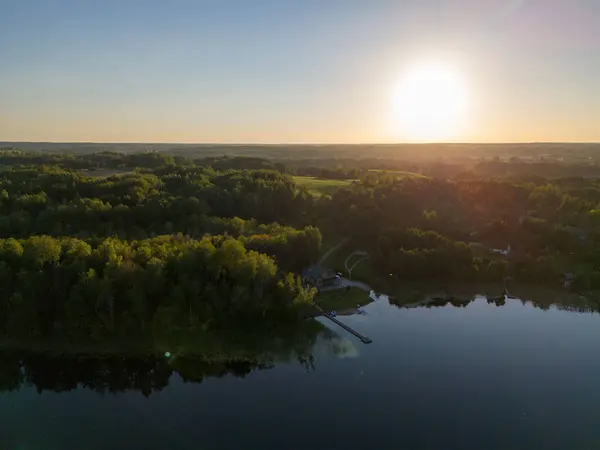 Yoğun yeşil ormanlarla çevrili sakin bir göl manzarası doğanın sakin güzelliğini yansıtıyor..