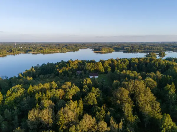 Yoğun yeşil ormanlarla çevrili sakin bir göl manzarası doğanın sakin güzelliğini yansıtıyor..
