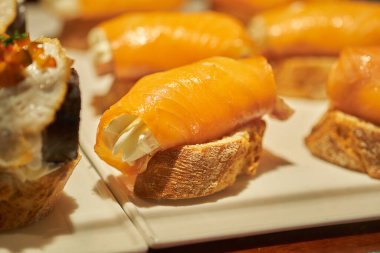 Bask ülkesinden tipik bir aperatif, pinthos ya da pintxos, barda yemeye hazır, soslu ya da malzemeli küçük dilimler, San Sebastian, İspanya, kapatın.