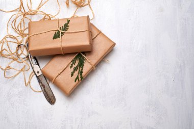 El işi kağıdına sarılı hediye kutuları beyaz arka planda ip yay kurdelesi, üst manzara. Noel kutlaması için maket. Boşluğu kopyala.