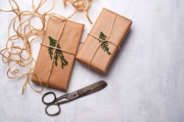 El işi kağıdına sarılı hediye kutuları beyaz arka planda ip yay kurdelesi, üst manzara. Noel kutlaması için maket. Boşluğu kopyala.