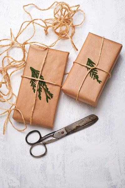 Gift boxes wrapped in craft paper craft rope bow ribbon on a white background, top view. Mockup for christmas celebration. Copy space.