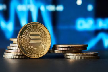 Mavi tonda grafik arkaplanı olan altın Solana kripto para birimine yakın plan