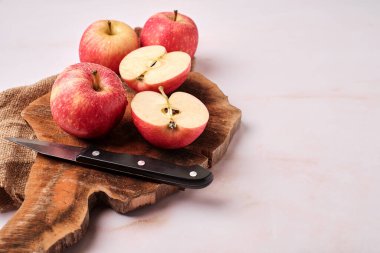 Lezzetli kırmızı elmalar, tahta tahtada bir kesik, yukarıdan yazı ve manzara için boşluk