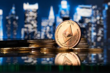 Altın Ethereum kripto para biriminin daha fazla madeni para ve çözünmüş gökdelenlerin arka planı ile çevrili yakın plan