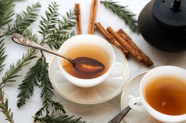 Siyah çay ve tarçın çubuklu iki beyaz seramik bardak.