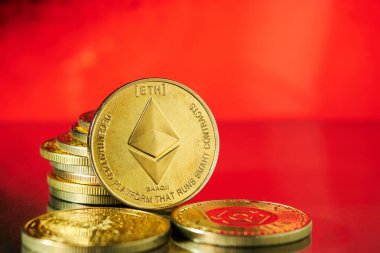 Kırmızı zemin ile Ethereum madeni paralarını vurgulayan çeşitli altın kripto birimleri