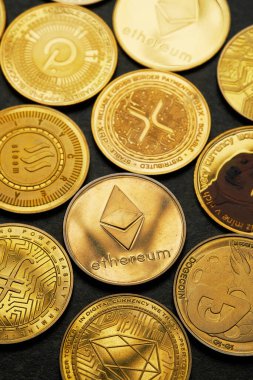 Koyu taşlı arka plan ve yukarıdan görüntülenmiş çeşitli kripto para birimlerinin arkaplanı