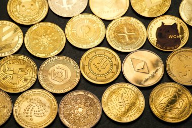 Koyu taşlı arka plan ve yukarıdan görüntülenmiş çeşitli kripto para birimlerinin arkaplanı