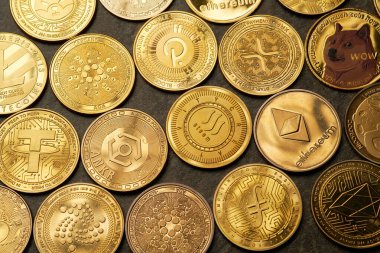 Koyu taşlı arka plan ve yukarıdan görüntülenmiş çeşitli kripto para birimlerinin arkaplanı