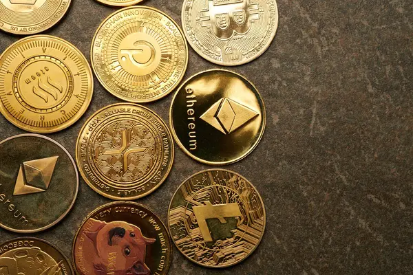Koyu taşlı arka plan ve yukarıdan görüntülenmiş çeşitli kripto para birimlerinin arkaplanı