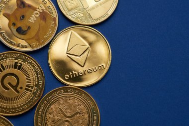 Mavi arka planda birkaç altın kripto para birimi ve Ethereum sikkesi vurgulanıyor.