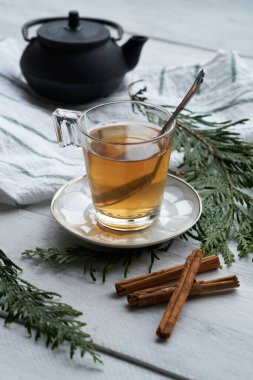 Siyah çay ve tarçın çubuklu beyaz bir seramik bardak.