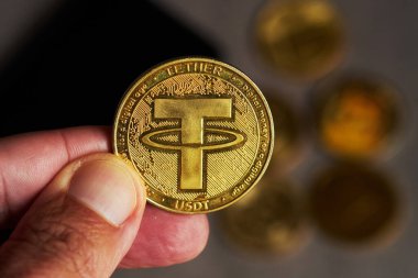 Altın kripto para birimi bağlayıcısını tutan elin yakınlaştırılması