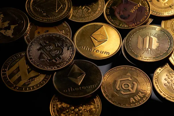 Karanlık bir yüzeye yerleştirilmiş çeşitli altın kripto para birimleri, yatırımlarda kullanılan popüler dijital para birimlerini vurgular..