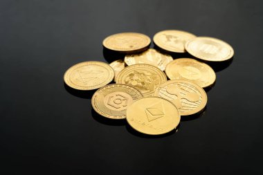Karanlık bir yüzeye yerleştirilmiş çeşitli kripto para birimleri benzersiz tasarımlarını ve özelliklerini vurguluyor..