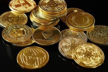 Karanlık bir yüzeye yerleştirilmiş çeşitli kripto para birimleri benzersiz tasarımlarını ve özelliklerini vurguluyor..