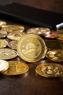 Daha fazla kripto para ile çevrili Uniswap bir akıllı telefon yanında koyu bir ahşap masaya yayılmış dijital finansman için artan ilgi vurgulanan.