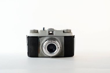 Klasik bir vintage kamera sade bir arkaplanda gösteriliyor, retro tasarımını ve karmaşık ayrıntılarını vurguluyor, fotoğraf meraklıları için nostalji uyandırıyor.