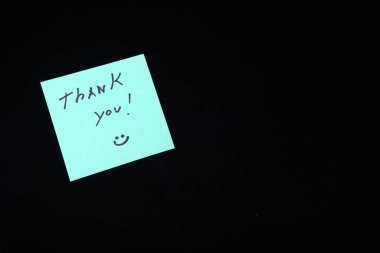 Koyu mavi arka planda yapışkan bir notta 