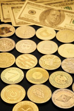 Değişik kripto para birimleri karanlık bir yüzeydeki banknotların arasına dağılmış durumda, geleneksel ve dijital para birimleri arasındaki zıtlığı gösteriyor..