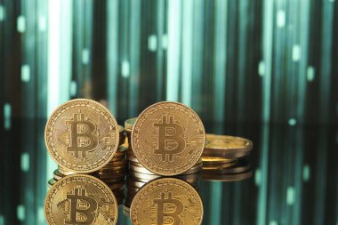 Parlak bitcoin para yığınları yansıtıcı bir yüzey üzerinde zarifçe düzenlenirken, grafiksel grafikler arka planda kripto para eğilimleri gösterir.