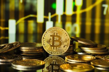 Altın bitcoin sikkeleri yansıtıcı bir yüzeye yerleştirilerek kripto para piyasası eğilimleri ve fiyat dalgalanmalarının dijital gösterimine karşı değerlerini gösterirler..