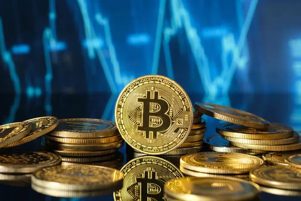 Altın bitcoin sikkeleri yansıtıcı bir yüzeye yerleştirilerek kripto para piyasası eğilimleri ve fiyat dalgalanmalarının dijital gösterimine karşı değerlerini gösterirler..