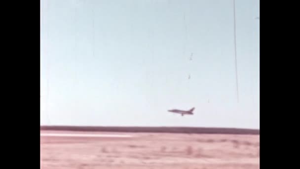 冷战时期的美国战斗机降落在军用机场跑道上 在罕见的档案镜头中 广角全景跟随视图 美国1950年代北美F 100型超音速喷气式战斗机 — 图库视频影像