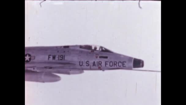 戦闘機の機首が雲の上を飛行し コックピット内の軍用パイロットが別の飛行機によって形成された アメリカ1950年代北米F 100スーパーセイバー超音速ジェット戦闘機 — ストック動画