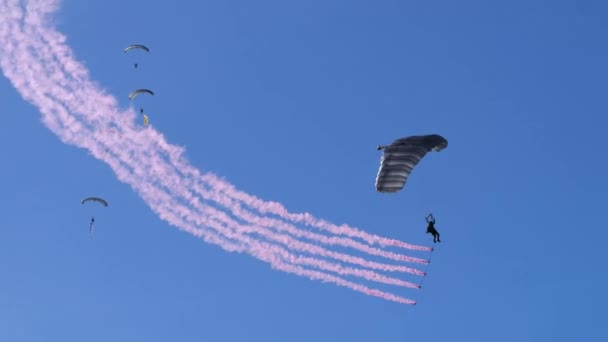 Military Paratrooper Descends Blue Sky Five Red Smoke Hanging His — Stock Video