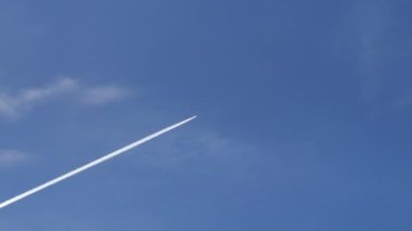 Mavi gökyüzündeki bir uçağın izine rastladık. Chemtraces komplo teorisi. Beyaz buhar, soğuk bir kış gününde, parlak bir ışıkla yüksek irtifada uçan bir uçak tarafından üretilir..