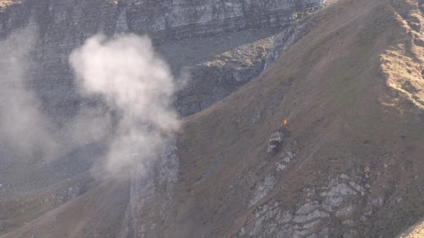 砲弾が山に命中し爆発すると煙が上がる ベルネーゼ オーバーランド スイスのアクサルプ射撃場 — ストック動画