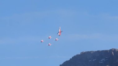 Savaşçı jetleri mavi gökyüzünde kırmızı beyaz renkte İsviçre bayrağıyla çapraz uçuyor. İsviçre Hava Kuvvetleri Patrouille Suisse 'den Northrop F-5E Tiger II. Axalp hava gösterimi İsviçre
