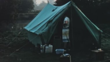 A close-up of a camping setup with cooking utensils and a camping stove, ready to be used for preparing a meal. Longridge Activity Centre, UK, 1970 retro high-quality stock footage.