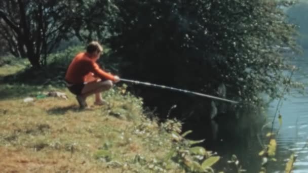 在20世纪70年代 人们看到一个小男孩正享受着用渔网捕鱼的和平时光 风景如画 绿树成荫 清澈清澈的大海 Longridge活动中心 英国1970年 — 图库视频影像