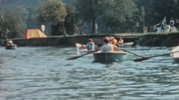 青空と緑に囲まれたテムズ川でカヌーを漕ぐ少年たち 少年たちは決意と集中力でパドルし 水の中で楽しく冒険的な一日を楽しんでいます 長尾根活動 — ストック動画