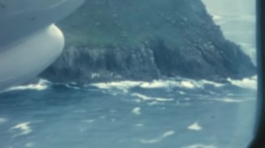 Flying over British cliffs as seen from inside a small propeller-driven passenger plane. Britten-Norman BN-2 Islander. United Kingdom 1970s. Restored High-Quality Historical Stock Footage