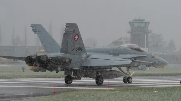 空軍の防空ジェットは滑走路に並んで 灰色の曇った冬の日にバックグラウンドのコントロールタワーで離陸を待っていました スイス空軍のマクドネル ダグラスF 18ホーネット マイリンゲン空軍基地 — ストック動画