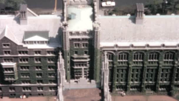 一座历史建筑的空中录像展示了它复杂而详细的立面和它后面的街道 建筑物的设计和繁忙的街道充满了移动的汽车 1960年代的历史镜头 — 图库视频影像